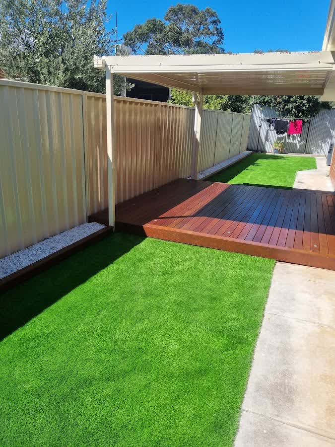Two-level timber deck stepping down to a fresh turf backyard